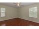 Bedroom features a ceiling fan, wood floors, and natural light from two windows at 15313 Hayworth Dr, Winter Garden, FL 34787
