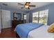 Charming bedroom featuring hardwood floors, a dresser, a ceiling fan, and a bright window view at 15313 Hayworth Dr, Winter Garden, FL 34787