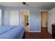 A serene bedroom featuring hardwood floors, a ceiling fan, and a view to the ensuite bathroom at 15313 Hayworth Dr, Winter Garden, FL 34787