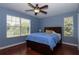 A serene bedroom with a ceiling fan, a large bed, hardwood floors, and natural light at 15313 Hayworth Dr, Winter Garden, FL 34787