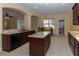 Large kitchen with an island, granite countertops, dark wood cabinets, and a view of the dining area at 15313 Hayworth Dr, Winter Garden, FL 34787