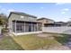 Exterior rear view showcasing the home's back patio, green lawn, and privacy fence at 15318 Beamleigh Rd, Winter Garden, FL 34787