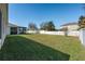 Sprawling backyard with lush green grass and a white vinyl privacy fence at 15341 Urbino Ln, Orlando, FL 32828