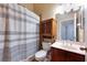 This half bathroom features tiled floors, a vanity, medicine cabinet, and shower with curtain at 15341 Urbino Ln, Orlando, FL 32828