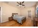 Comfortable bedroom featuring ceiling fan, wood floors and adjacent bathroom at 15341 Urbino Ln, Orlando, FL 32828