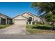 Charming single-story home with a two-car garage, brick driveway, and manicured lawn at 15341 Urbino Ln, Orlando, FL 32828