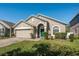 Charming single-story home featuring a well-manicured lawn and attached two-car garage at 15341 Urbino Ln, Orlando, FL 32828