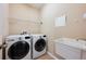 Well-lit laundry room features a washer, dryer, and utility sink at 15341 Urbino Ln, Orlando, FL 32828