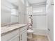 Bright bathroom featuring a granite countertop, white cabinets, and a shower-tub combo at 1595 Juniper Hammock St, Winter Garden, FL 34787