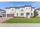 Stunning two-story home features a manicured lawn, three car garage, and elegant architectural details at 1595 Juniper Hammock St, Winter Garden, FL 34787