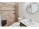 Bathroom featuring a tiled walk-in shower, single sink vanity, and decorative mirror at 18468 Sabal St, Orlando, FL 32833