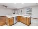 Kitchen featuring wooden cabinets, stainless steel dishwasher and sink, with views to the living area at 18468 Sabal St, Orlando, FL 32833