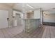 Well-lit kitchen featuring white cabinetry, tile floors, and open access to the living area at 2021 Canal Rd, Deltona, FL 32738