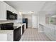 Well-lit kitchen featuring white cabinets and modern black appliances at 2021 Canal Rd, Deltona, FL 32738