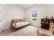 Cozy bedroom with a daybed, a suitcase-style table, and a woven chair, featuring a bright window at 2067 Buckhanon Trl, Deland, FL 32720