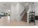 Hallway view featuring a staircase, a closet, and an ornamental rack in a well-lit, tiled space at 2067 Buckhanon Trl, Deland, FL 32720