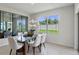 Dining room featuring a glass table, white chairs, decorative mirror, and natural light from the window at 2149 Pigeon Plum Dr, Haines City, FL 33844