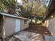 Exterior view of yard showing block construction, small window, neutral paint color, and tree coverage at 220 Palm Ave, Auburndale, FL 33823