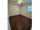 Cozy bedroom illuminated by a ceiling fan and a window, adorned with hardwood floors at 220 Palm Ave, Auburndale, FL 33823