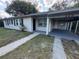 Exterior shot of a light grey house with a covered parking spot at 220 Palm Ave, Auburndale, FL 33823