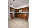 Traditional-style kitchen featuring wooden cabinets, tiled floors, and granite countertops at 220 Palm Ave, Auburndale, FL 33823