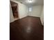 Living room area with dark floors, a window and an opening to the kitchen at 220 Palm Ave, Auburndale, FL 33823