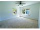 Bright bedroom featuring two windows, a ceiling fan, and neutral carpeting at 2401 S Myrtle Ave, Sanford, FL 32771