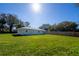 Backyard exterior view of house with a spacious lawn and blue skies at 2401 S Myrtle Ave, Sanford, FL 32771