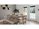 Dining room featuring a wooden table, bench seating, and natural light from the adjacent backyard access at 2751 Carmel Ct, Kissimmee, FL 34746