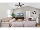 Cozy living room featuring neutral tones, vaulted ceiling, comfortable seating, and a ceiling fan at 2751 Carmel Ct, Kissimmee, FL 34746