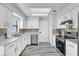 Bright eat-in kitchen with stainless steel appliances, light countertops, white cabinetry, and modern backsplash at 2923 Cornell Ave, Orlando, FL 32804