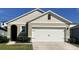 A charming single-story home featuring a two-car garage, manicured lawn, and neutral-toned siding at 2981 Moulin Rd, Davenport, FL 33837