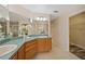 Bathroom featuring a large mirror over double sinks, wood cabinets, and tile flooring at 330 Hickory Springs Ct, Debary, FL 32713