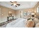 Neutral bedroom with tray ceiling, ceiling fan, wood floors, and decorative console table with wall art at 330 Hickory Springs Ct, Debary, FL 32713