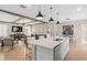 Open concept kitchen with island, pendant lights, and stainless sink flows into the living room with beamed ceilings at 3438 Orange Rose Loop, Apopka, FL 32712