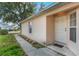 Exterior shot of the front entryway and an adjacent window, all set against green grass at 350 Lakebreeze Cir, Lake Mary, FL 32746