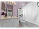 Bathroom features a lavender painted wall, a large mirror, and a toilet with a storage cabinet at 3569 Bellington Dr, Orlando, FL 32835