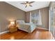 Cozy bedroom with wood floors, a ceiling fan, natural light, and simple decor at 3569 Bellington Dr, Orlando, FL 32835