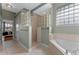 Modern bathroom with a glass block shower, soaking tub, neutral tiling, and light green walls at 3569 Bellington Dr, Orlando, FL 32835