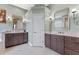 Spacious bathroom with dual sinks, dark wood vanities, and stylish wall sconces at 3569 Bellington Dr, Orlando, FL 32835