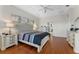 Bright main bedroom featuring a tufted headboard, ceiling fan, bedside tables, and wood flooring at 3569 Bellington Dr, Orlando, FL 32835