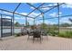 Screened patio area featuring a table and chairs, surrounded by landscaping, providing a relaxing outdoor space at 3569 Bellington Dr, Orlando, FL 32835