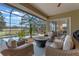 A screened patio with a view of the pool and outdoor furniture, including rocking chairs and a sofa at 3569 Bellington Dr, Orlando, FL 32835