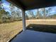 A covered back patio overlooks the grass and the treeline at 3660 Pandora Dr, Indian Lake Estates, FL 33855