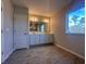 Bright bathroom featuring double vanity, wood-look tile floor, and a large window with a pleasant outdoor view at 3660 Pandora Dr, Indian Lake Estates, FL 33855