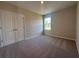 Bedroom featuring a double door closet, neutral carpeting, and natural light from the window at 3660 Pandora Dr, Indian Lake Estates, FL 33855