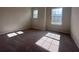 Bedroom with two windows letting in light, neutral walls, and neutral carpeting at 3660 Pandora Dr, Indian Lake Estates, FL 33855