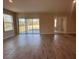 Spacious living room featuring wood-look tile flooring and a sliding glass door at 3660 Pandora Dr, Indian Lake Estates, FL 33855