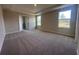 Spacious main bedroom with carpet flooring, tray ceiling, and windows overlooking the backyard at 3660 Pandora Dr, Indian Lake Estates, FL 33855