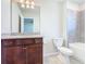 Bathroom with granite counters, dark cabinets, and large mirror with vanity lighting at 3751 Lana Ave, Davenport, FL 33897